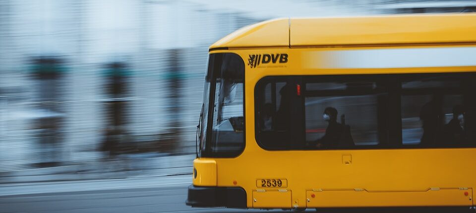 a yellow bus on a wet road
